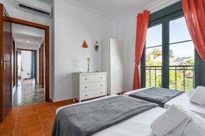A hotel room with two beds, a dresser, a mirror, and a window with curtains. - El Rincon del Golf II - Isla Canela Golf GRHII54P57 (Ayamonte)
