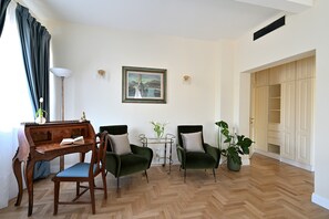 A living room with a wooden desk, two green armchairs, a small table with a vase, and a framed picture on the wall. - Your Private Tuscan Villa 17 Min to Florence · Private Pool · 6 Suites · 7 Baths (Firenze)