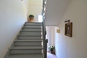 A staircase with a handrail, a potted plant at the top, and a framed picture on the wall. - Your Private Tuscan Villa 17 Min to Florence · Private Pool · 6 Suites · 7 Baths (Firenze)