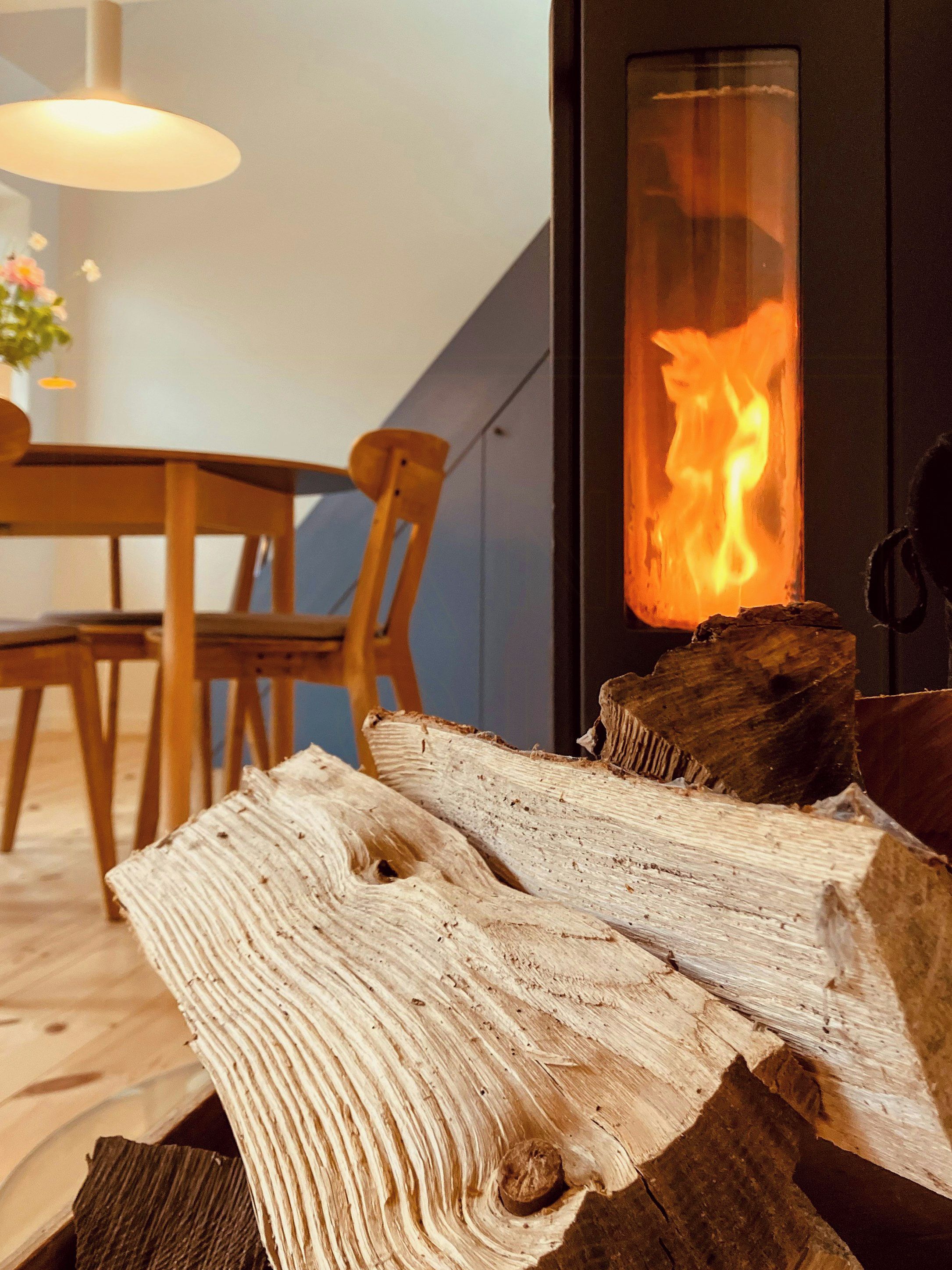 A room with a fireplace, wooden furniture, and a visible fire.