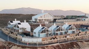 A modern building with multiple structures, including a large central building and several smaller ones with solar panels.