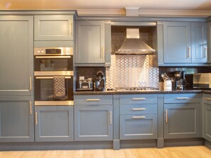 A modern kitchen with grey cabinetry, stainless steel appliances, and a patterned backsplash. - Skeabost Bungalow by Interhome (Mid Skye)