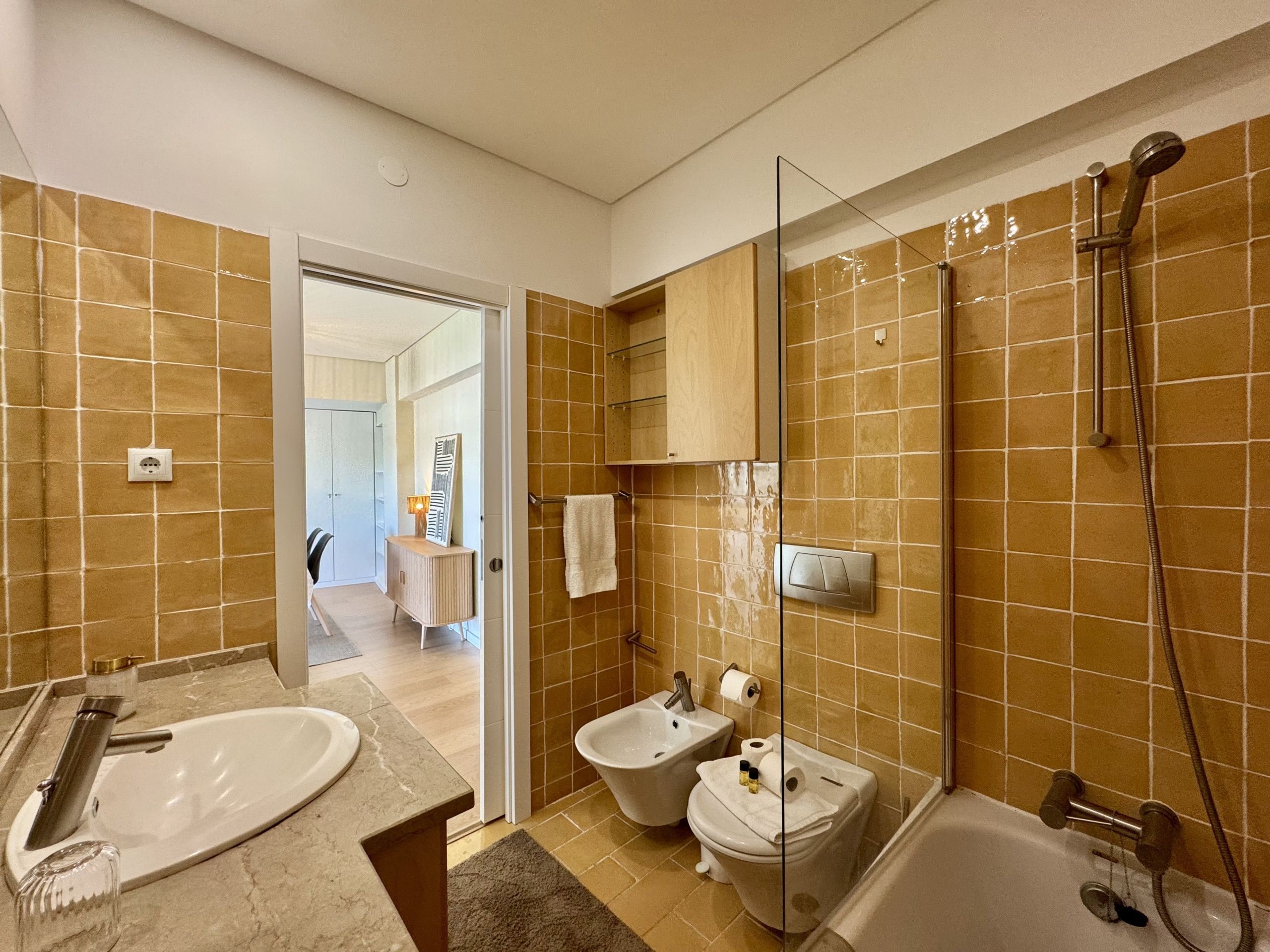 A modern bathroom with a bathtub, two sinks, and a shower.