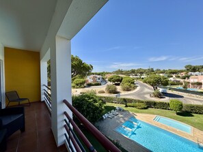 A balcony with a view of a swimming pool and a residential area. - Vilamoura Golf Apartment 4 by Homing (Loulé)