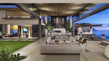 A modern interior with a central seating area, a kitchen, and a dining space with a view.
