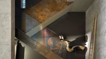 Un interior moderno con una escalera, una escultura de madera y una escalera de mano.