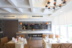A restaurant with a chalkboard menu, wooden tables, and a chandelier. - Bright Hotel Khon Kaen (Khon Kaen)