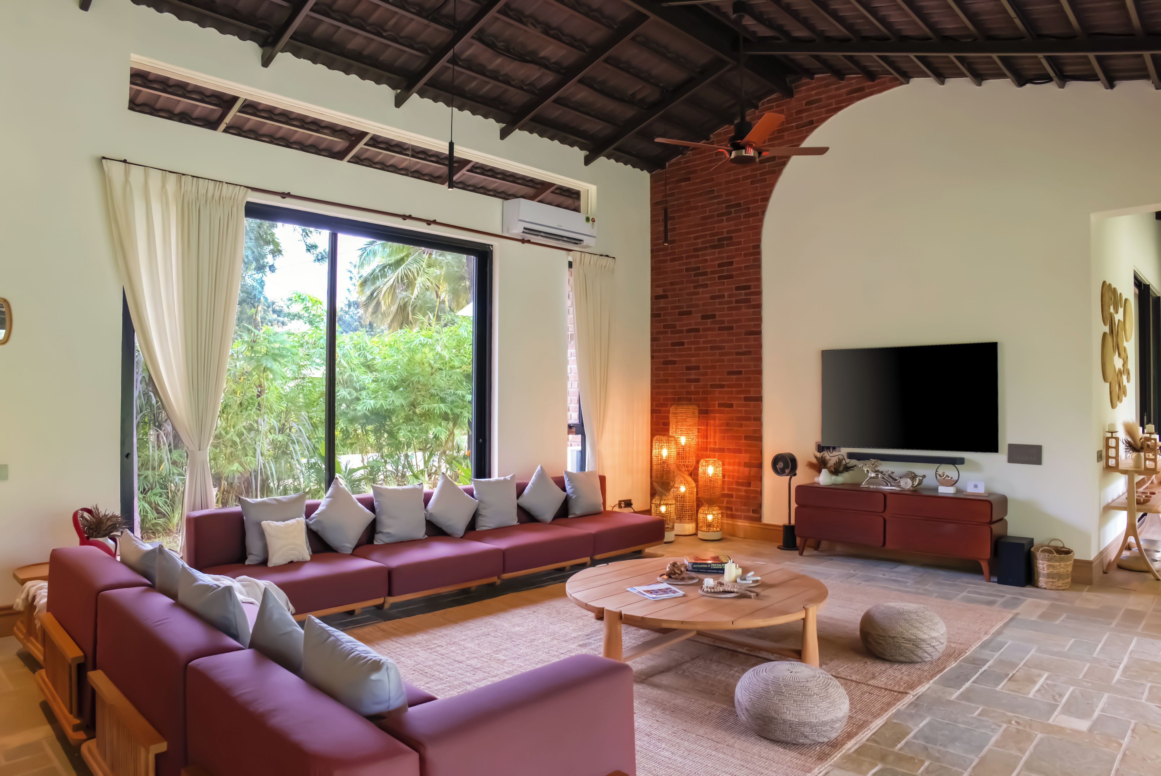 A spacious living room with a large sofa, a coffee table, and a TV.