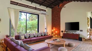 A spacious living room with a large sofa, a coffee table, and a TV.