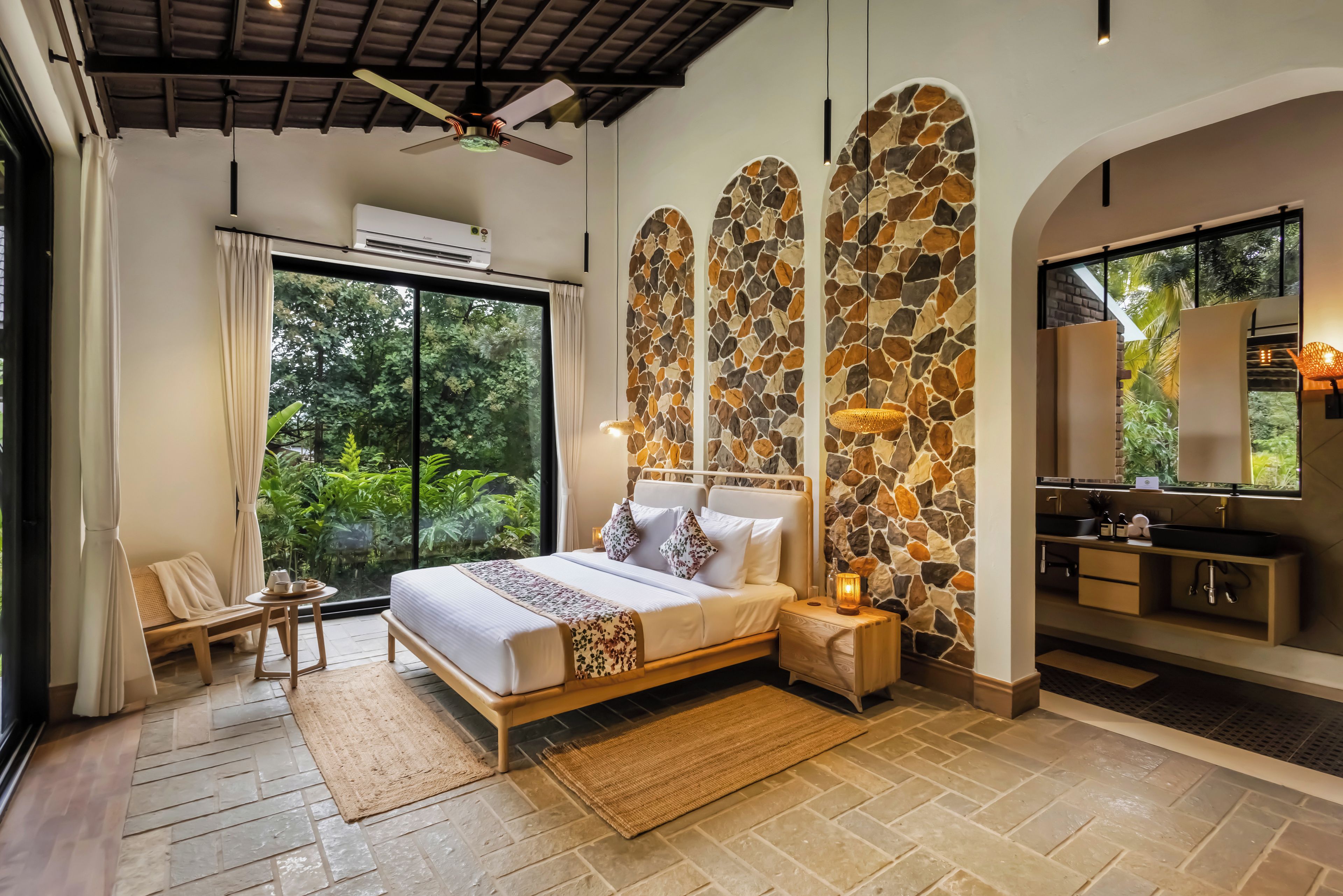 Un dormitorio con cama, mesita de noche y vistas al exterior.