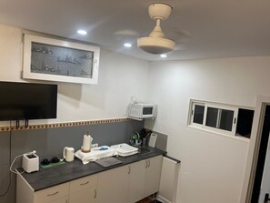 A kitchen with a microwave, toaster, and a framed cityscape picture on the wall. - Vacation Apartment 'Estudio Kylie' with Sea View, Wi-Fi and Air Conditioning (Santa Cruz de Tenerife)