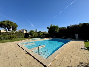 A rectangular swimming pool with a clear blue water, surrounded by a tiled deck. - VILAMOURA GOLF APARTMENT 4 WITH POOL by HOMING (Vilamoura)