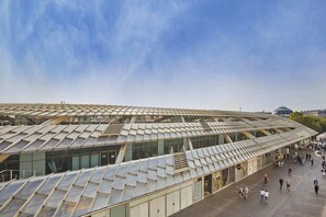 A modern building with a distinctive geometric roof structure and a glass facade. - Elegant Renovated Suite – Montorgueil Center Paris (Paris)