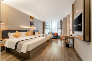Una habitación de hotel con una cama grande, un escritorio y un televisor.