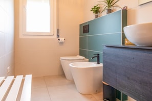 Une salle de bain moderne équipée de toilettes, d’un bidet et d’un lavabo.