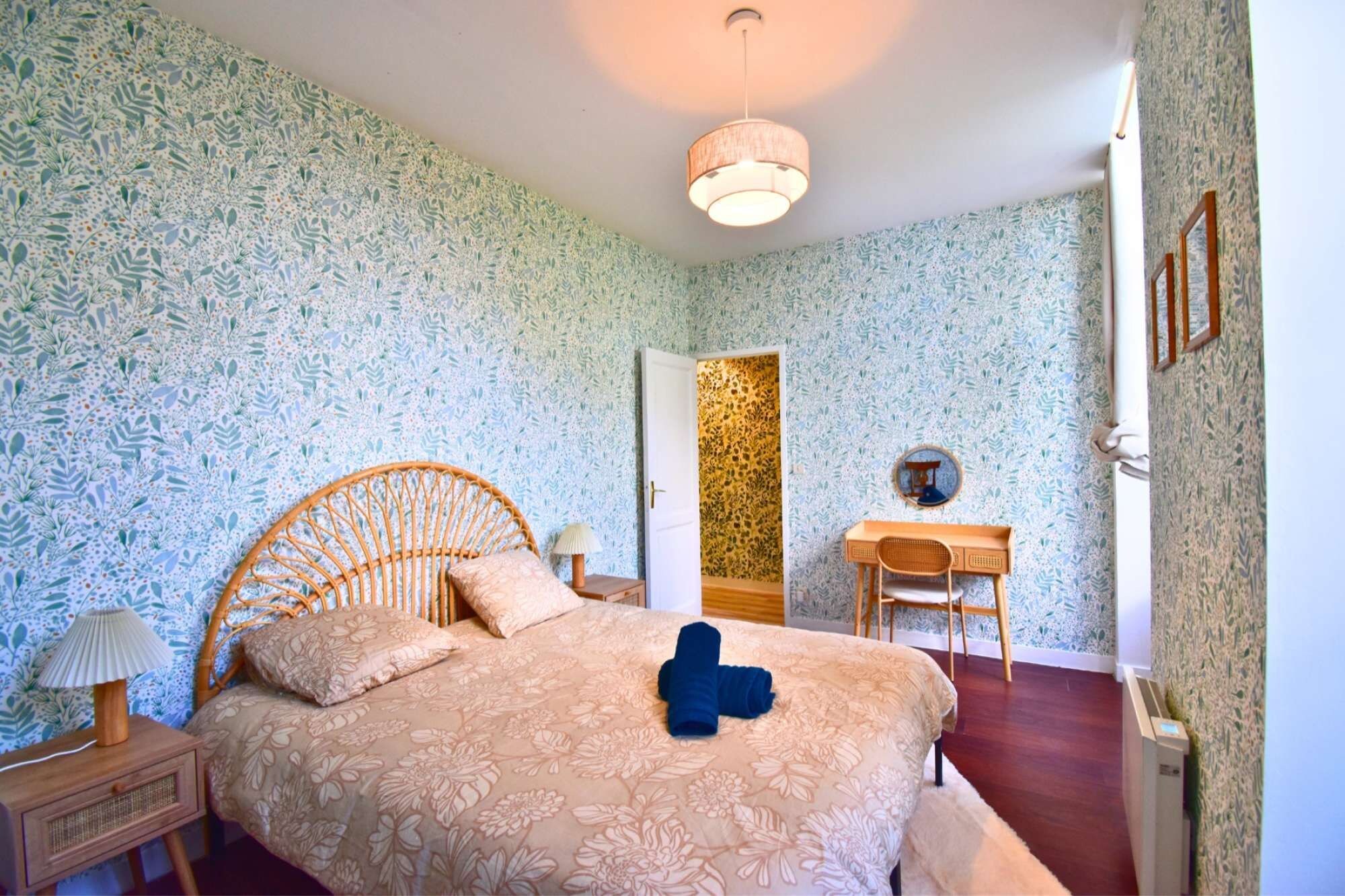 Een slaapkamer met een bed, een bureau, een stoel en een kledingkast.