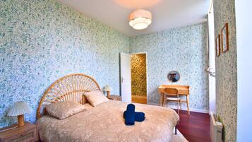 Een slaapkamer met een bed, een bureau, een stoel en een kledingkast.
