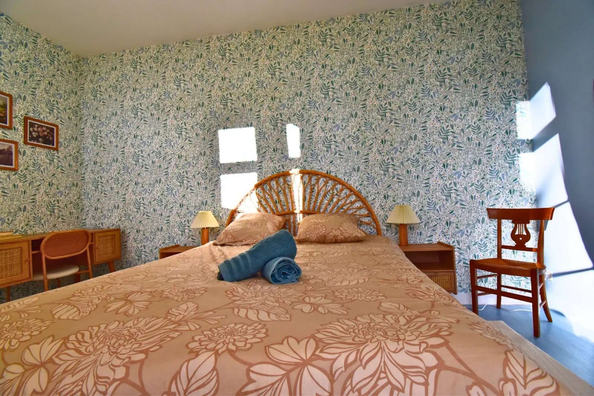 Een slaapkamer met een bed, twee nachtkastjes, een stoel en een raam.