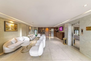 A modern hotel lobby with a reception desk, seating area, and artwork on the walls. - A25 Hotel 55 Cach Mang Thang 8 (Ho Chi Minh Municipality)