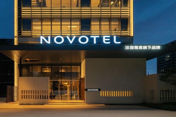 Entrada d'un hotel modern amb un destacat rètol de 'NOVOTEL'.