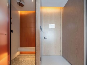 Un passadís estret amb una porta de fusta i una panxa.