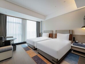 A hotel room with two beds, a desk, a chair, and a large window with curtains. - Novotel Zibo New Hongcheng (Zibo)
