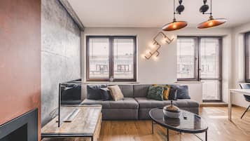 Una sala moderna con sofá, mesa de centro y chimenea.