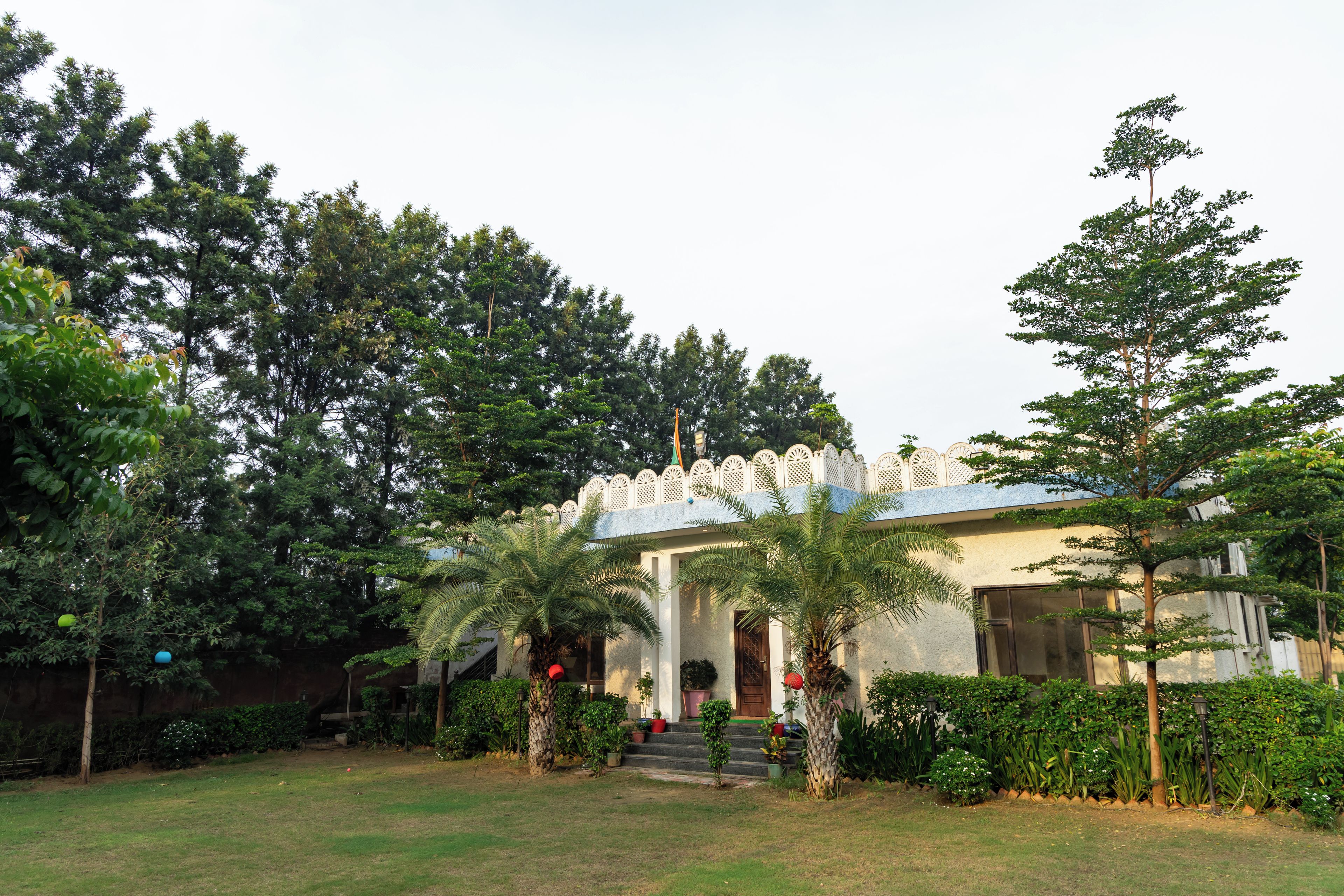 A building with a traditional architectural style, surrounded by lush greenery and trees.