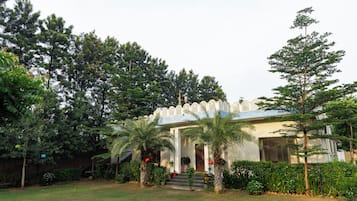 A building with a traditional architectural style, surrounded by lush greenery and trees.