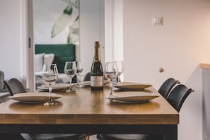 A dining table set with plates, glasses, and a bottle of champagne. - Puszcza Białowieska Apartments by 2HomeRent (Nieznany Bór)