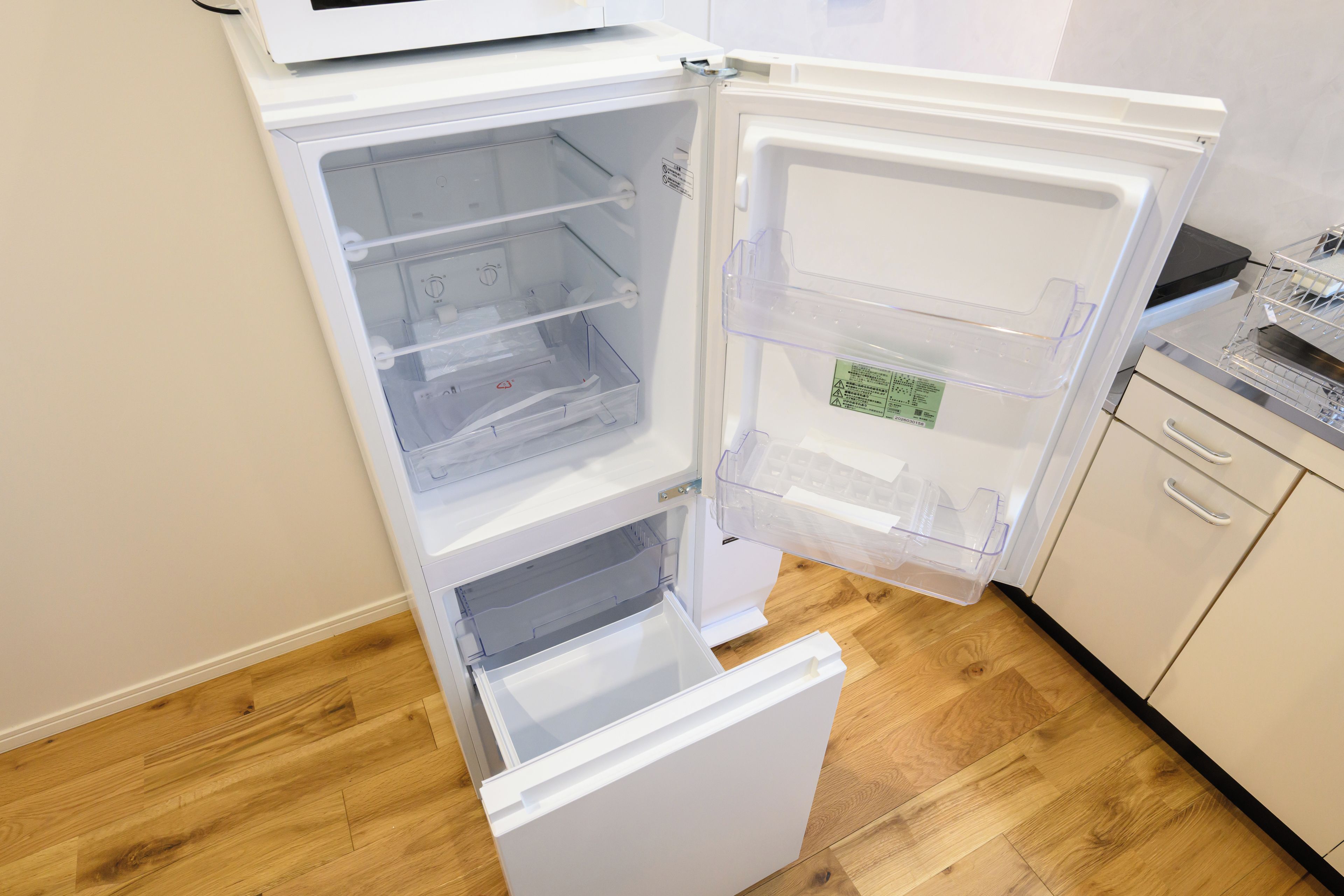 Un refrigerador abierto con varios estantes y un compartimento congelador.