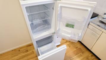 Un refrigerador abierto con varios estantes y un compartimento congelador.