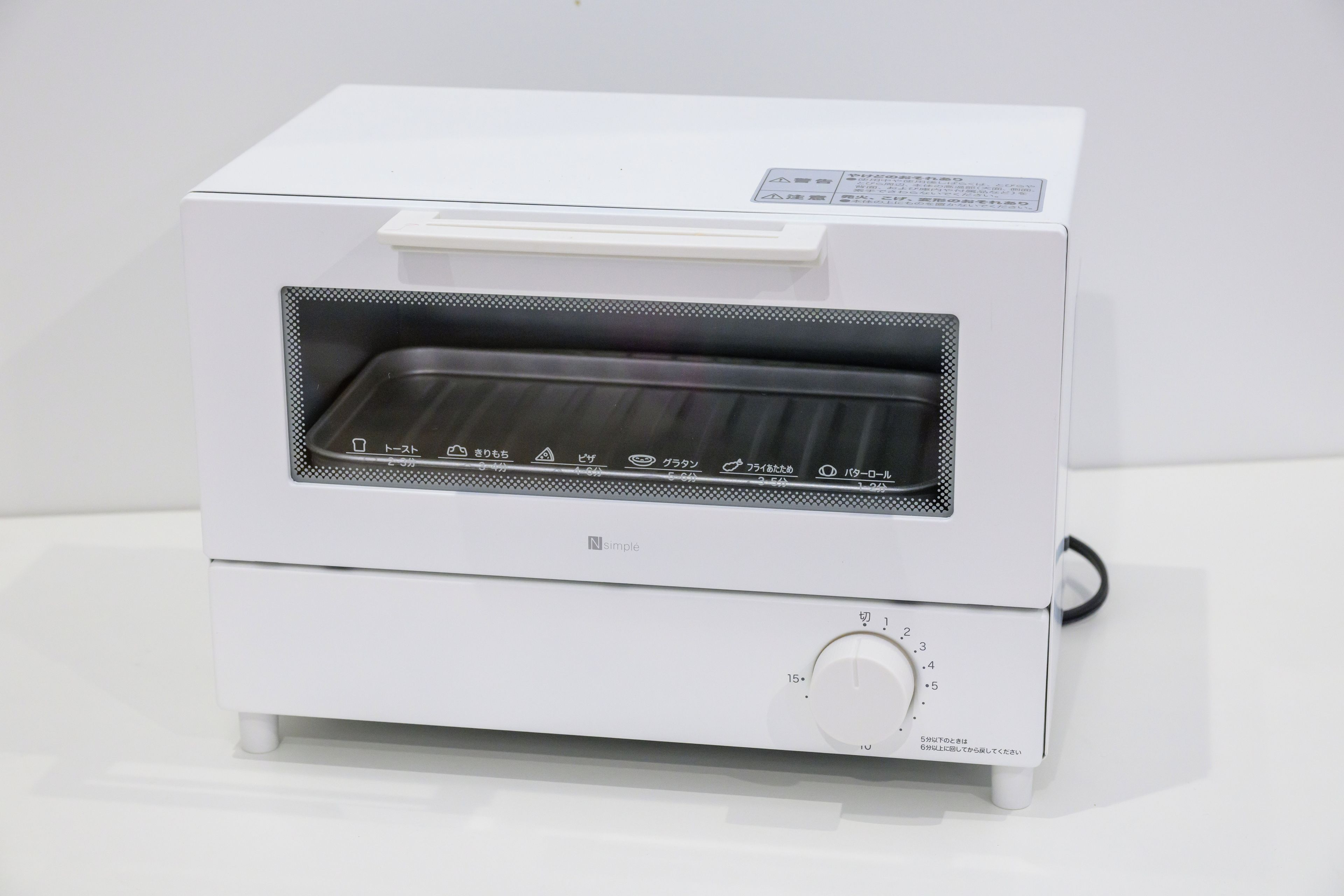 A white toaster oven with a control panel and a handle.