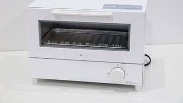 A white toaster oven with a control panel and a handle.