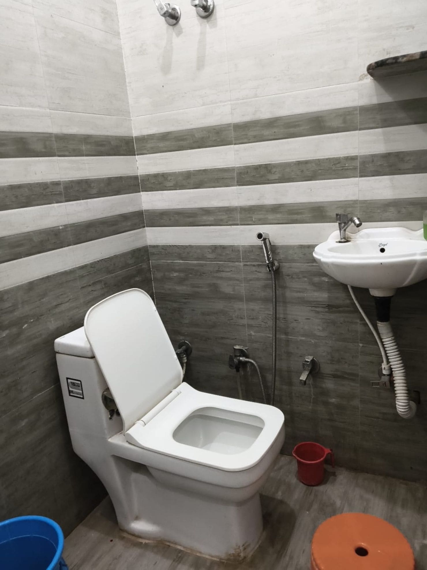 Un baño con inodoro, lavamanos y ducha.