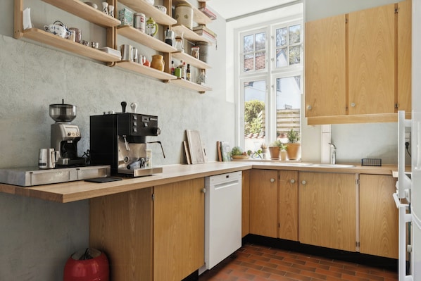 Una cocina con armarios de madera, una cafetera y una ventana con vistas al exterior.