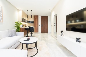 A modern living room with a sofa, a coffee table, and a TV mounted on the wall.
