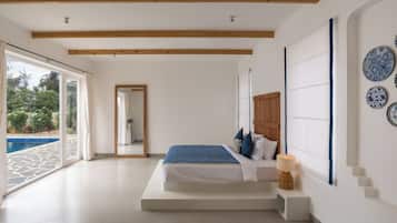 Un dormitorio con una cama grande, techo de madera, vista a una piscina y un espejo.