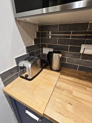 A kitchen with a toaster, a kettle, and a tiled backsplash. - 16097522 FRGK 5-Apartment Building - Downtown Cannes - Conference Special - 47 rue Meynadier (Cannes)