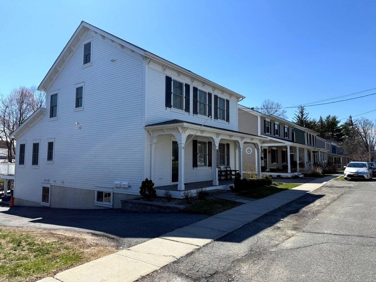 A two-story residential building with a porch and a garage.