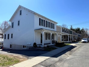 A two-story residential building with a porch and a garage.