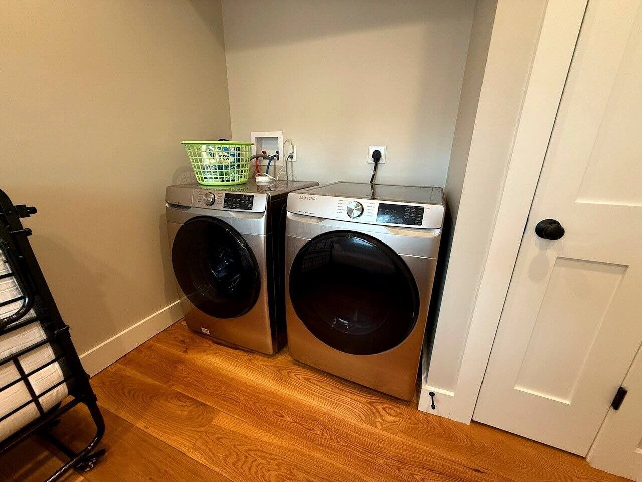 A laundry room with two front-loading washing machines and a dryer.