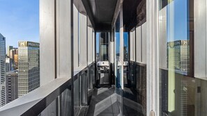 A narrow corridor with a view of the cityscape through large windows. - Home Views on Collins – light filled CBD apartment with pool, gym and elevated views (Melbourne)