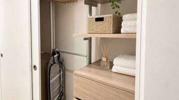 A walk-in closet with wooden shelves, hanging space, and drawers.