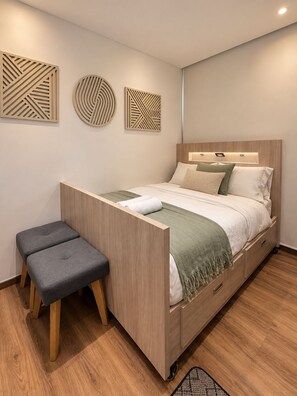 A modern bedroom with a bed, bedside tables, and decorative wall art. - Sophisticated Apartment in Chapinero Norte Bogota (Bogotá)