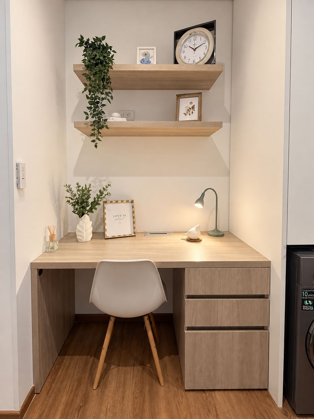 Un espacio de trabajo moderno con un escritorio de madera, una silla blanca, un estante en la pared con un reloj y una planta, y una lámpara de escritorio pequeña.