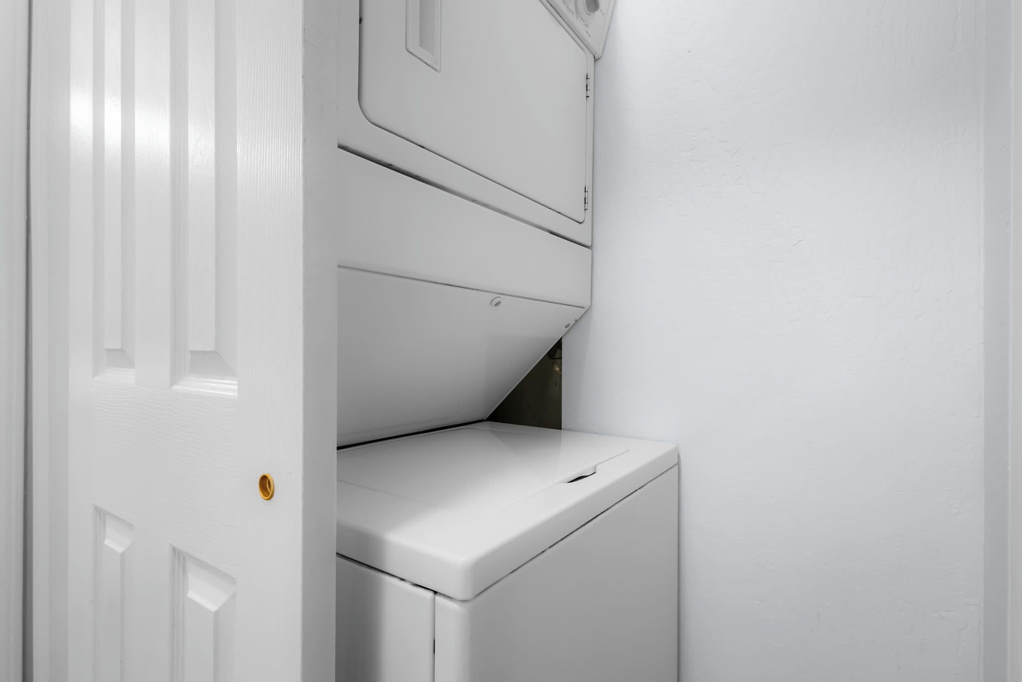 A white laundry room with a washing machine and a dryer.