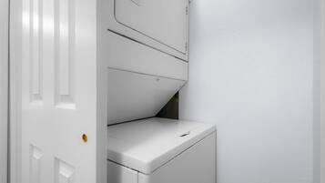 A white laundry room with a washing machine and a dryer.