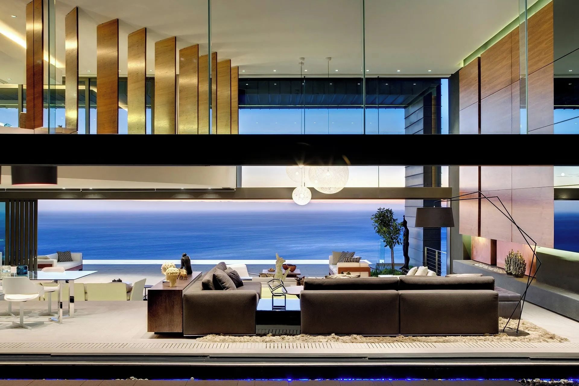 Una sala de estar moderna con un sofá grande, una mesa de centro y vistas al océano.
