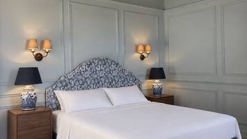 Een slaapkamer met een bed, nachtkastjes, wandlampen en een houten plafond.